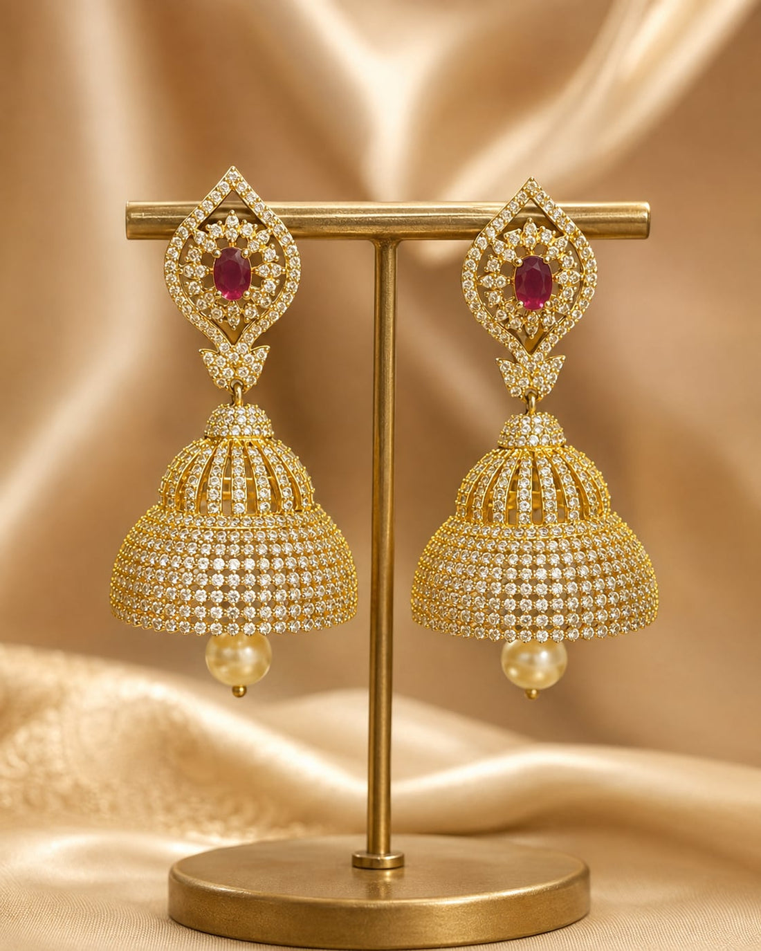 Front view of one matching pair of FeelOri gold-plated ruby paisley CZ bell jhumka earrings