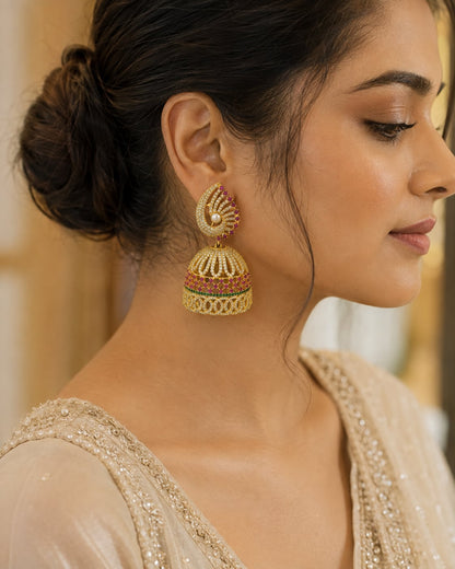 Model wearing FeelOri gold-plated ruby fan CZ jhumka earrings with pearl-look drops for Indian occasion styling
