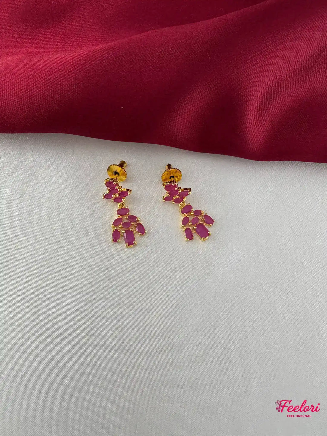 FeelOri Gold Plated Ruby Cluster Earrings - Detailed view of the intricate stud and drop design with multiple ruby-hued stones.