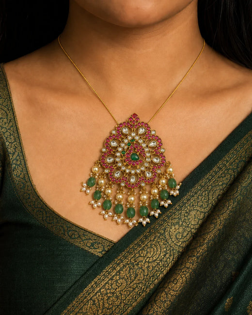 Model wearing the FeelOri Mayur Mandala Jadau Kundan peacock pendant with a dark green silk saree