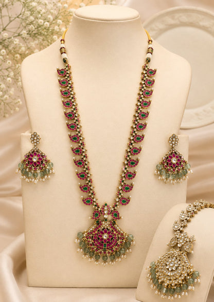 FeelOri ruby-tone and emerald-tone two-sided reversible long haram necklace set with matching earrings on jewellery display