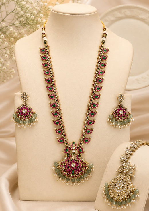 FeelOri ruby-tone and emerald-tone two-sided reversible long haram necklace set with matching earrings on jewellery display