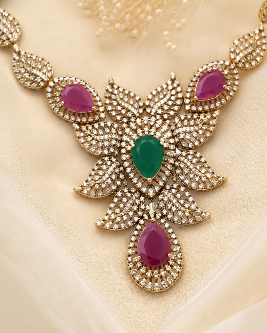 FeelOri ruby-tone and emerald-tone necklace set with matching earrings styled with saree fabric for Indian occasion wear