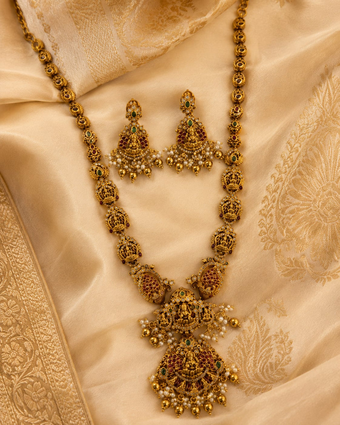 FeelOri ruby and emerald necklace set with matching earrings styled with saree fabric for Indian occasion wear