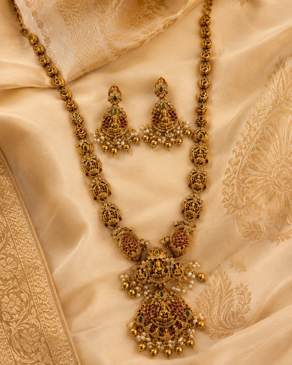 FeelOri ruby and emerald necklace set with matching earrings styled with saree fabric for Indian occasion wear