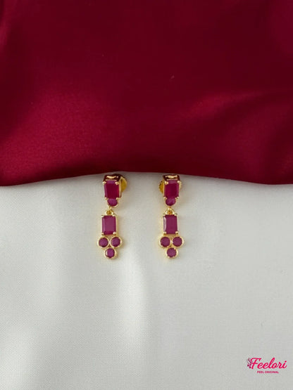 FeelOri Gold Plated Ruby Geometric Earrings - Close-up view of the matching drop earrings featuring rectangular and clustered round ruby-hued stones.
