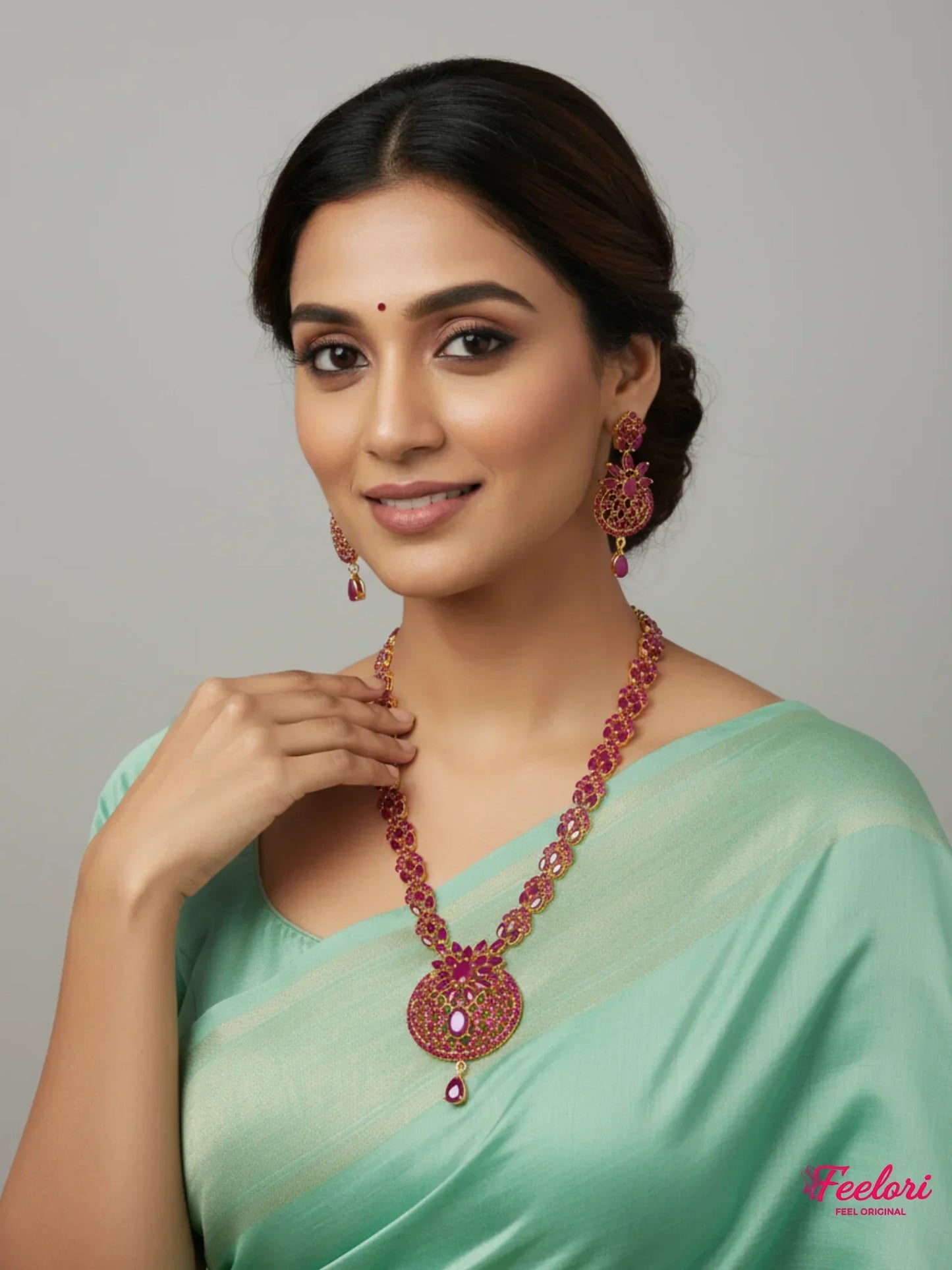 FeelOri Gold Plated Ruby Petal Necklace Set - Model wearing dazzling set with light green saree, smiling.